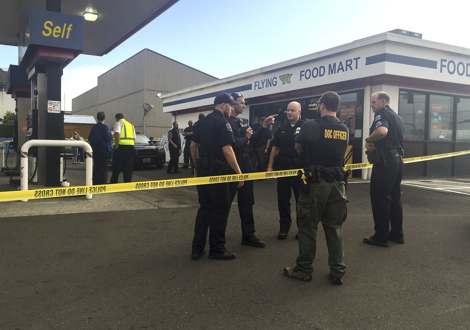 Officers are stationed outside the West Kelso Flying K gas station after an officer-involved shooting there Wednesday. A Kelso patrolman shot and killed a man who attacked a customer, a store clerk and the officer himself with a walking stick. (Lauren Kronebusch/The Daily News via AP)