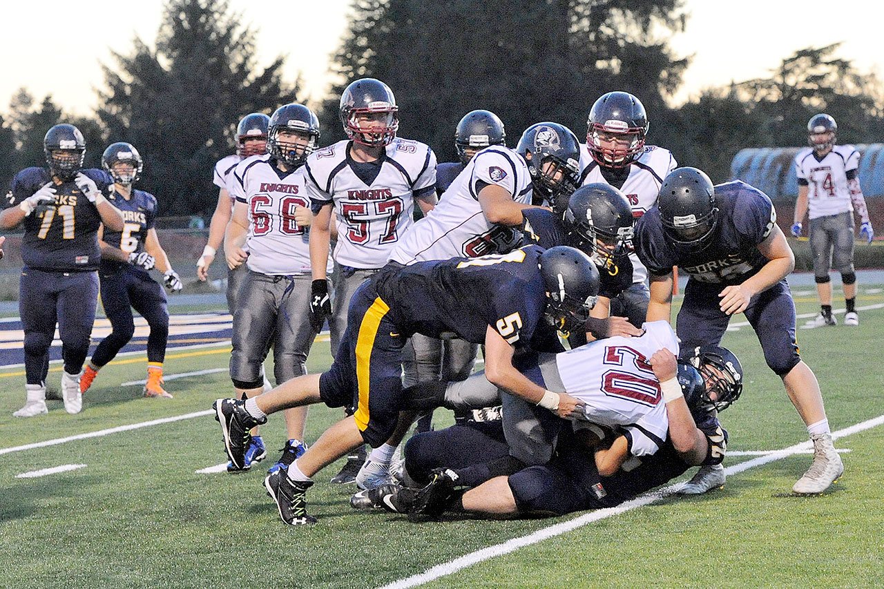 image 84=Forks’ Garrett Rondeau (72) along with a group of Spartans brings down Kings Way Christian’s Taj Muhammad (20). Lonnie.