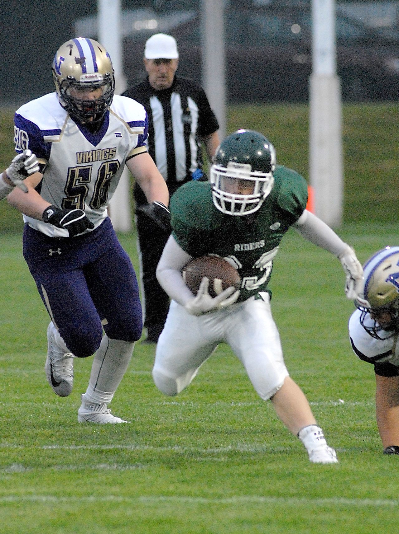 Keith Thorpe/Peninsula Daily News Port Angeles’ Trevor Shumway tries to evade the North Kitsap defense, including Oliver Chapmen, left, during the first quarter of Friday night’s game at Port Angeles Civic Field.