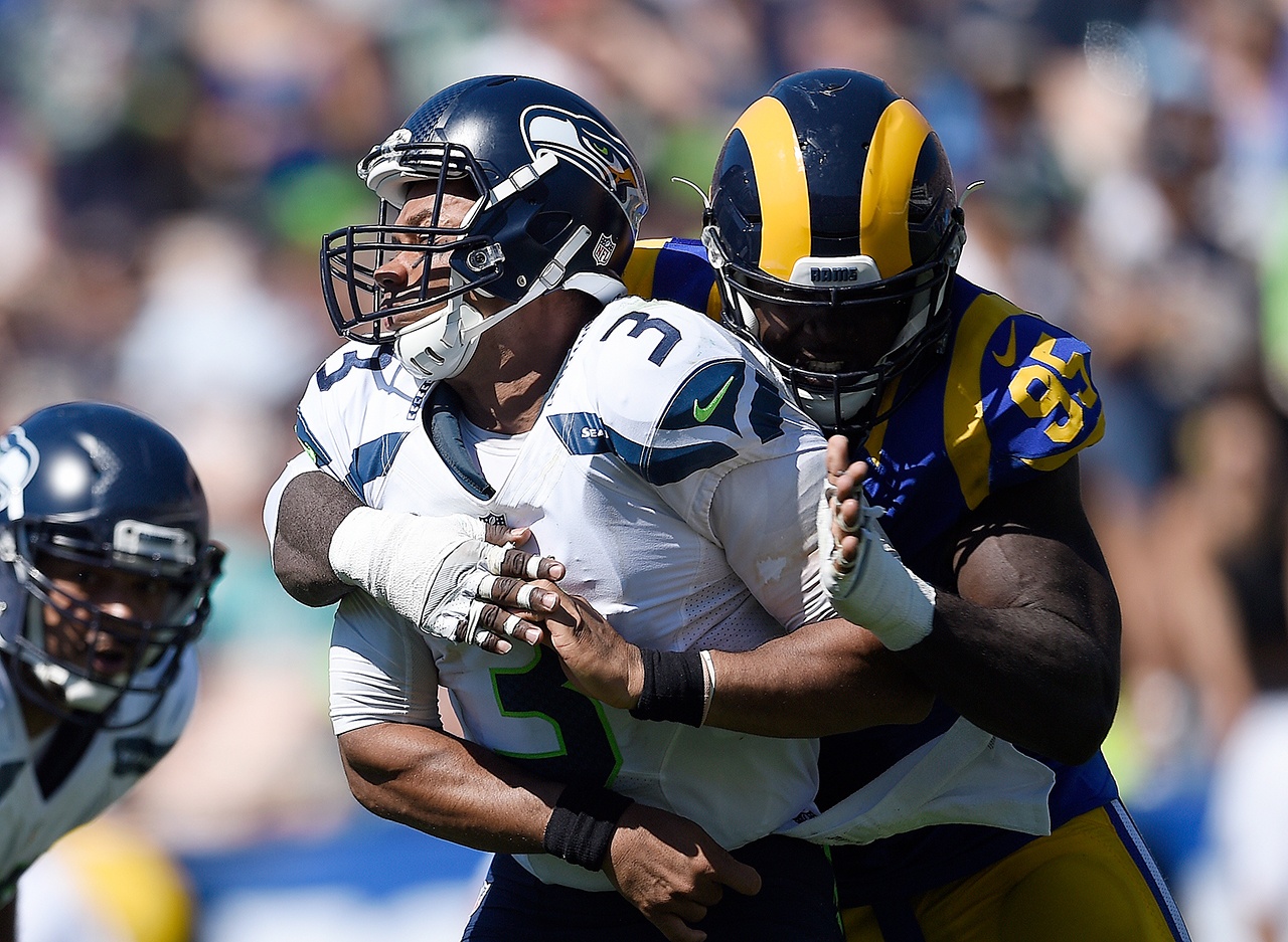 Seattle Seahawks quarterback Russell Wilson, left, is hit by Los Angeles Rams defensive end William Hayes after passing during the first half an NFL football game at the Los Angeles Memorial Coliseum, Sunday, Sept. 18, 2016, in Los Angeles. (AP Photo/Kelvin Kuo)