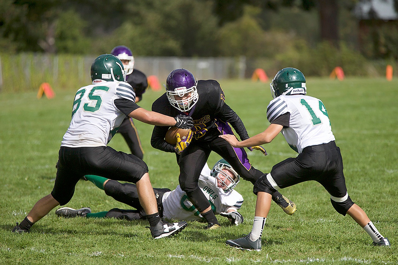 Steve Mullensky/for Peninsula Daily News Quilcene’s Olin Reynolds eluded one tackler but runs into Mary M. Knight’s Ina Frost, 85, and Ryly Oliver during the Rangers’ 52-0 victory.