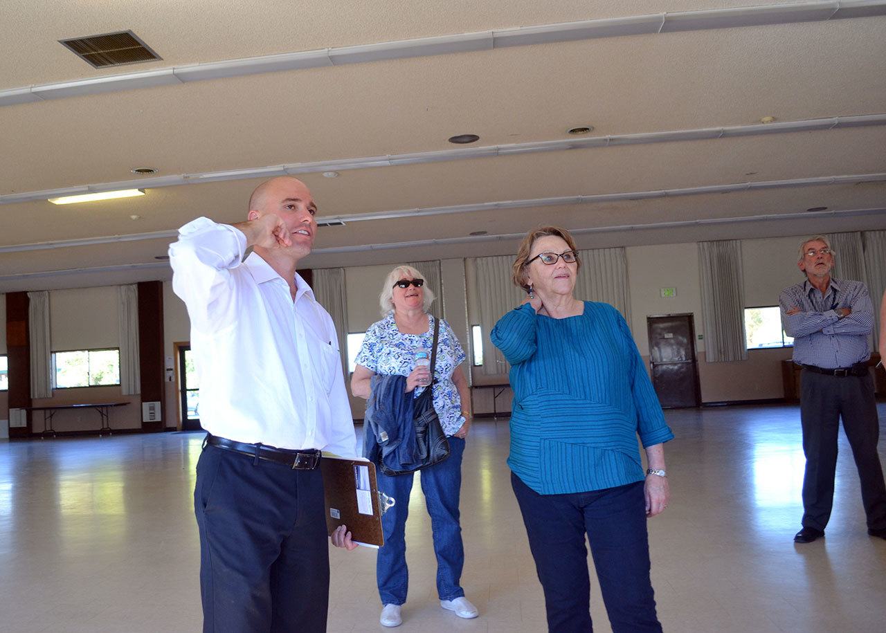 Joe Irvin, assistant to the city manager, discusses options for placing a donated glass elk window in the Guy Cole Convention Center with Sequim city councilors Pamela Leonard-Ray and Candace Pratt. Matthew Nash/Olympic Peninsula News Group