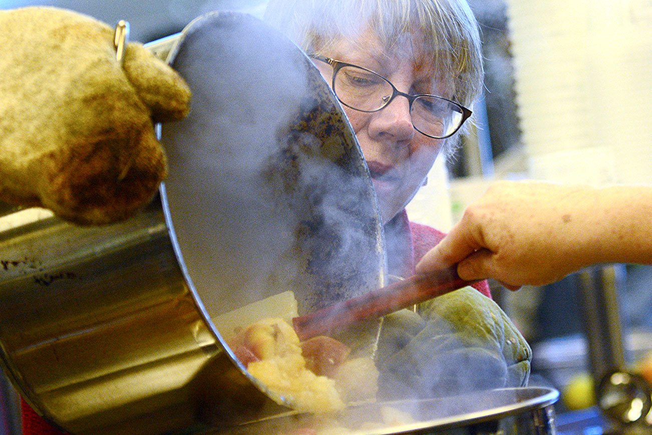 Volunteers turn 1,500 pounds of apples into applesauce for those in need