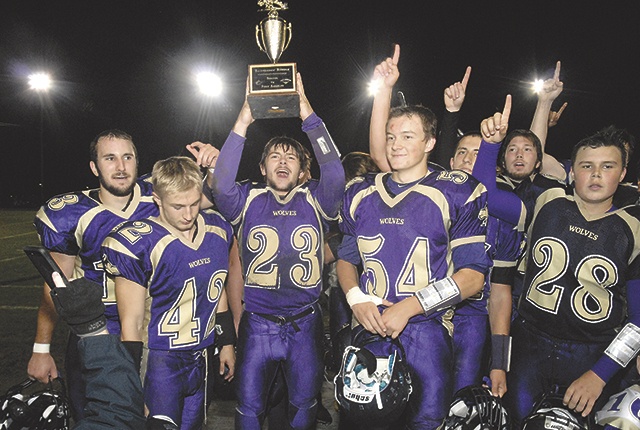 Keith Thorpe/Peninsula Daily News Gavin Velarde (23) holds up the Rainshadow Rumble trophy after Sequim defeated Port Angeles 49-6. Among those joining in the celebration were, front row from left, Ben Hughes, Bailey King, Velarde, Jack Ellison and Rudy Whitehead.