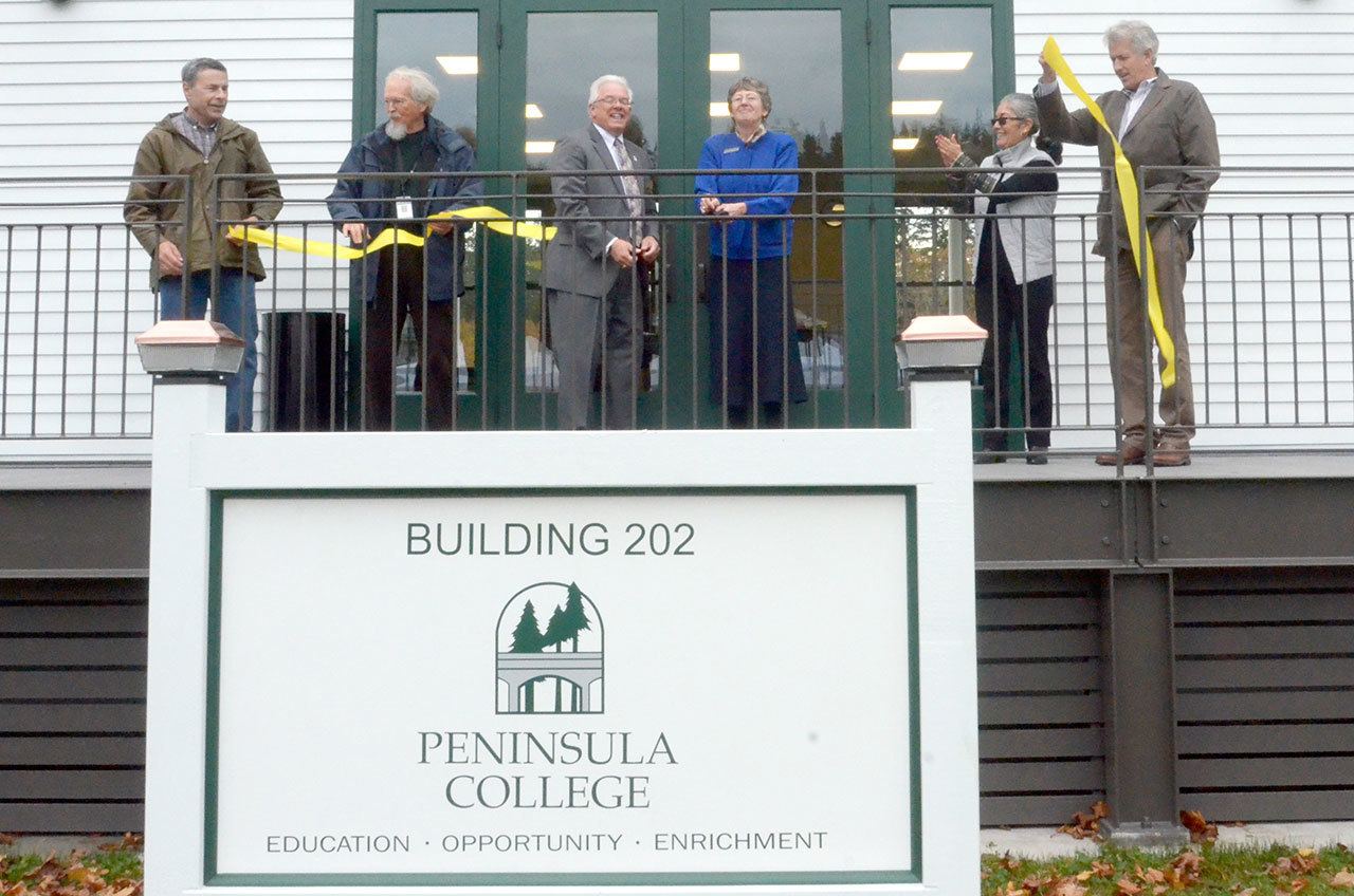 From left, David Timmons, Joe Floyd, Luke Robinson, Julie McCulloch, Michelle Sandovall and Dave Robinson cut the ribbon for the grand opening of Peninsula College’s new facility at Fort Worden State Park in Port Townsend. (Cydney McFarland/Peninsula Daily News)