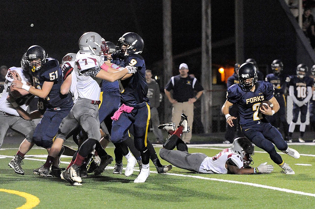 Lonnie Archibald/for Peninsula Daily News                                Forks’ Jeffery Schumack (2) looks for running room against Hoquiam behind the blocking of Billy Palmer (51) and Gavin Palmer (8).