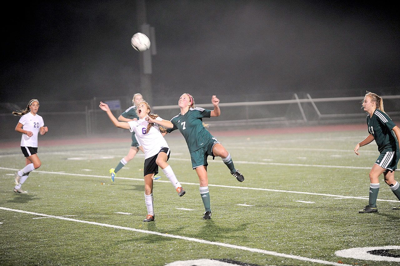 Matthew Nash/Olympic Peninsula News Group                                Sequim’s Jessica Dietzman and Port Angeles’ Kyrsten McGuffey jump for a loose ball during a West Central District tournament soccer match. The Roughriders won in penalty kicks to clinch their first state appearance in 30 years.