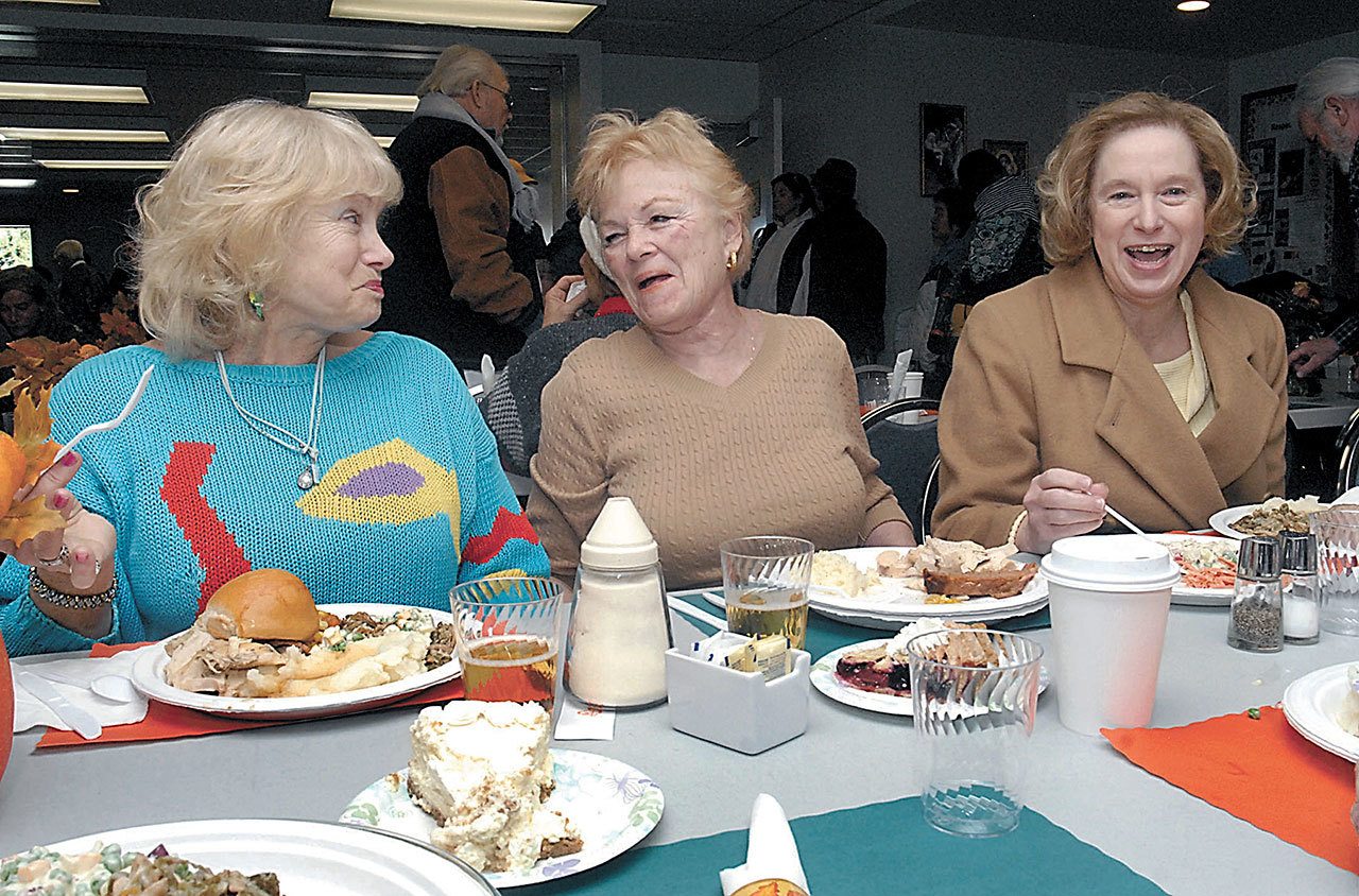 Diners, from left, Tina Harris of Port Angeles and Sande Fast and Beth Frazee, both of Sequim, share a moment of levity during the annual free community Thanksgiving dinner at Queen of Angels Catholic Church in Port Angeles last year. (Keith Thorpe/Peninsula Daily News)