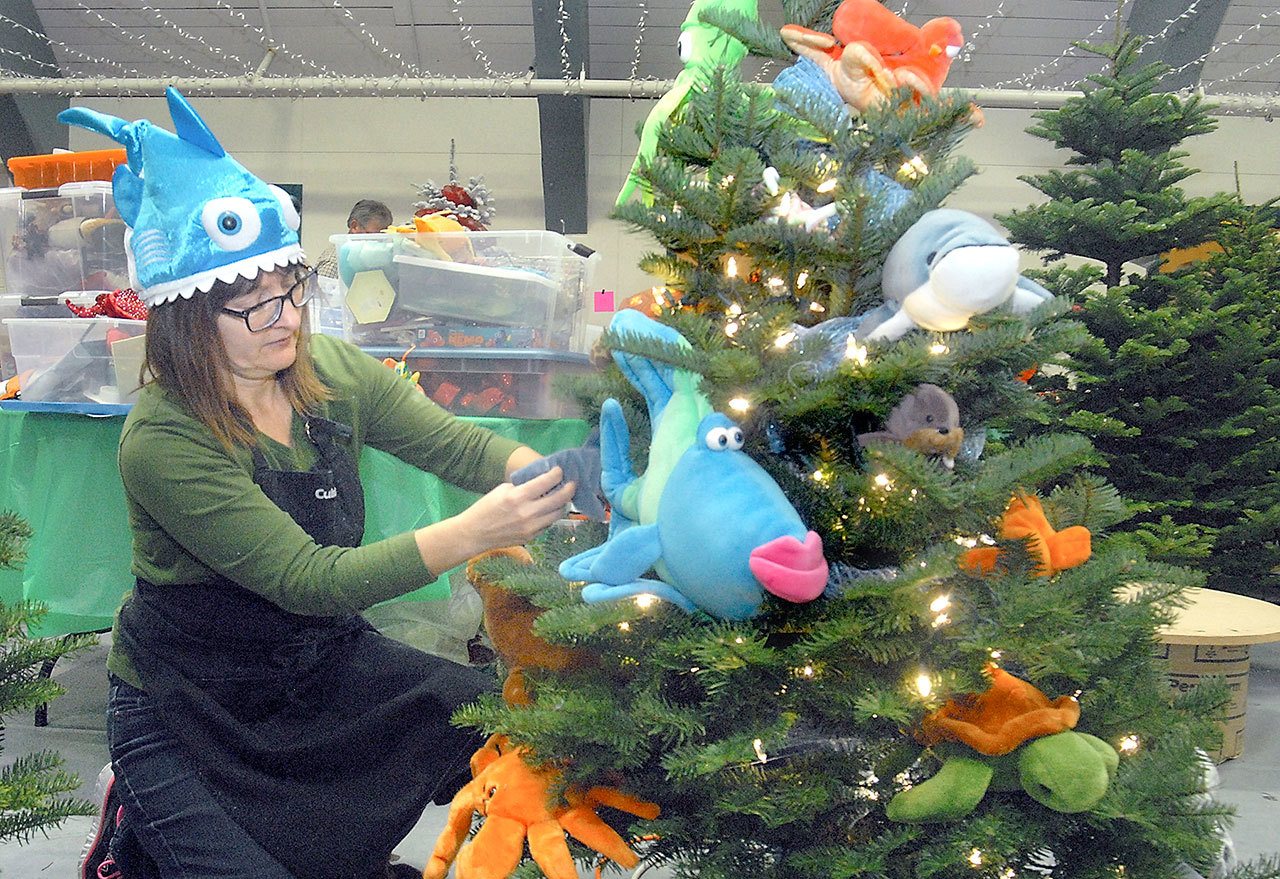 Sue Fink of Silverdale decorates a marine life-themed tree titled “Swimming Free” on Tuesday in preparation for this weekend’s Festival of Trees at the Vern Burton Community Center in Port Angeles. The festival, which begins today with the annual Teddy Bear Tea and Festival of Trees gala and auction, is a benefit for the Olympic Medical Center Foundation. (Keith Thorpe/Peninsula Daily News)