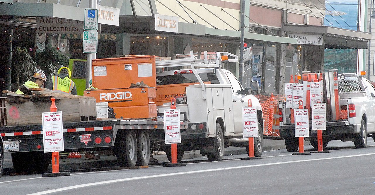 Temporary no-parking signs mark an area along West First Street in downtown Port Angeles on Wednesday where crews have removed trees to repair buckled sidewalks. (Keith Thorpe/Peninsula Daily News)