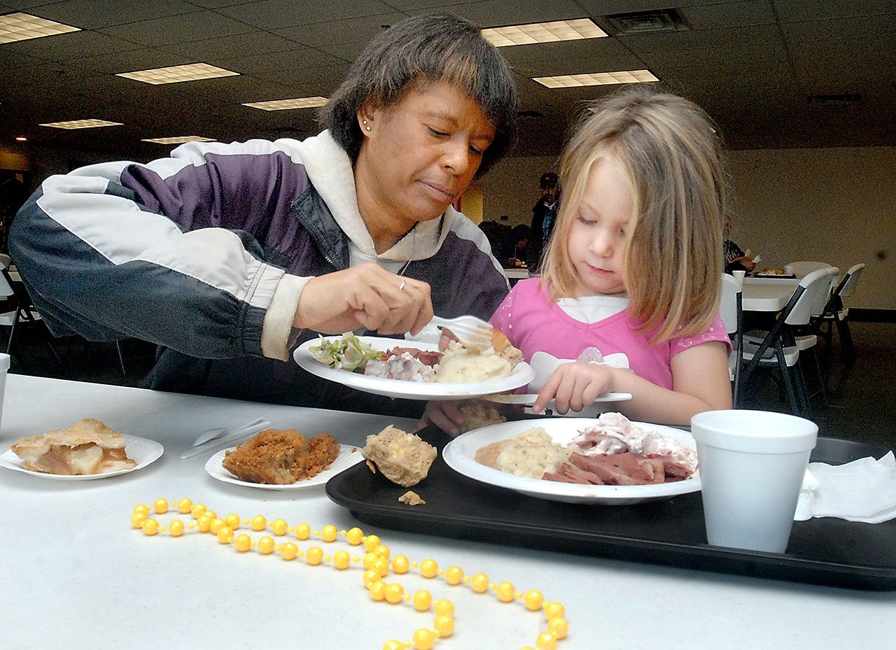 Tyrah Galbraith of Port Angeles, left, shares food with her daughter, Makailia Galbraith, 4, during Wednesday’s pre-Thanksgiving lunch at the Salvation Army kitchen in Port Angeles. (Keith Thorpe/Peninsula Daily News)