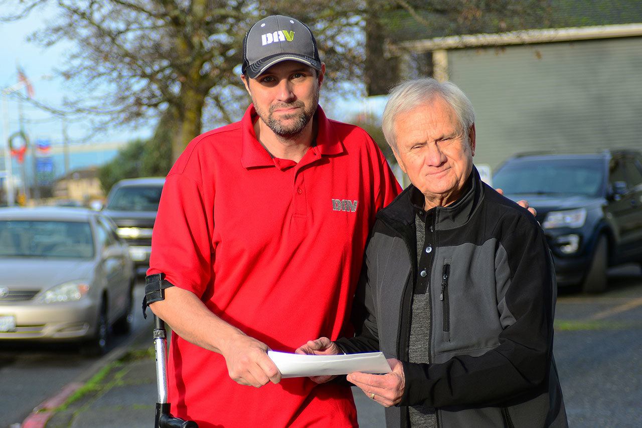 The Rev. Omer Vigoren of Bethany Pentecostal Church in Port Angeles, right, hands a $500 check to Jeff Bele, commander of Chapter 9 of the Disabled American Veterans in Port Angeles. The church is donating to a fund where 100 percent of the funds go toward helping disabled veterans financially. (Jesse Major/Peninsula Daily News)