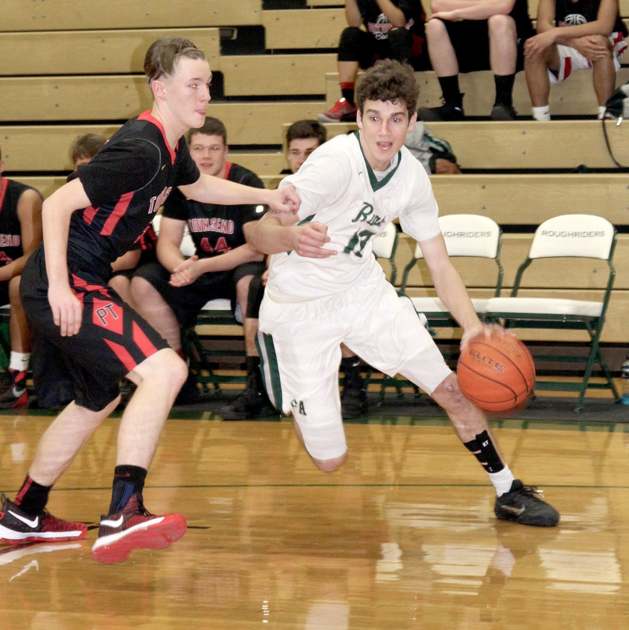 Dave Logan/For the Peninsula Daily News                                Port Angeles’s Luke Angevine, right, drives around Seth Spencer of Port Townsend at the Port Angeles Jamboree Monday night. The Roughriders hosted Port Townsend and Forks at the jamboree.