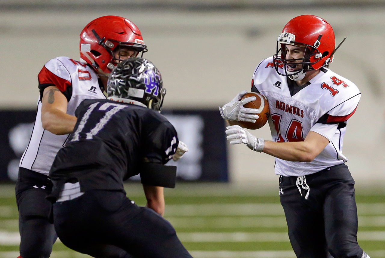 The Associated Press Neah Bay’s Cameron Buzzell, right, runs the ball as Nate Tyler (20) blocks Odessa-Harrington’s John DeWulf during the Red Devils’ 64-34 Class 1B state championship victory.