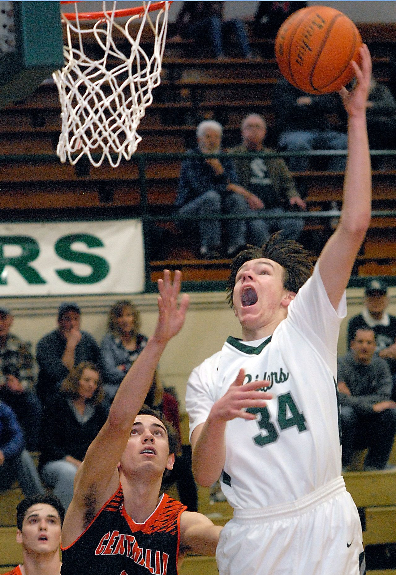 Keith Thorpe/Peninsula Daily News Port Angeles’ Liam Clark, right, goes for the layup over the defense of Centralia’s Layne Pertzborn in the fourth quarter on Wednesday afternoon at Port Angeles High School.