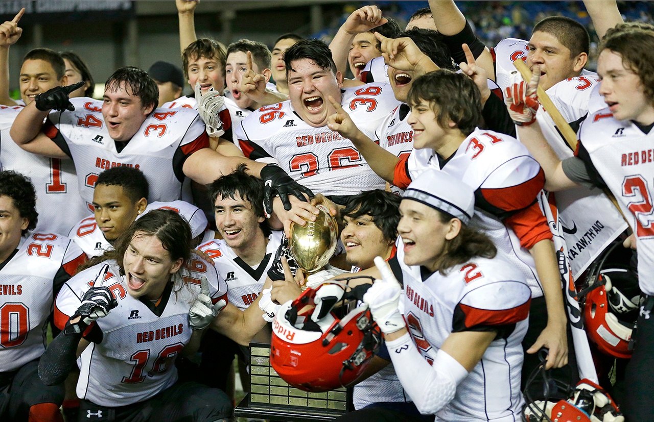 The Associated Press Neah Bay players celebrate with the trophy after they beat Odessa-Harrington 64-34 in the Class 1B state championship.