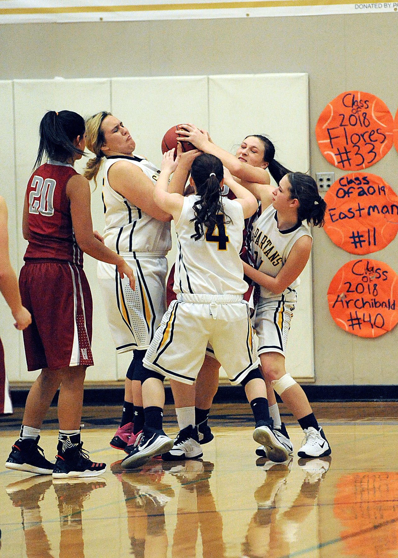 Lonnie Archibald/for Peninsula Daily News Forks Spartans from left, Brittney Woodruff, Skyler DeMatties (4) and Sage Baar compete with Hoquiam’s Rylee Vonhof for ball control. The Spartans won their first Evergreen League game since Feb. 4, 2014 in a 42-40 thriller over the Grizzlies.