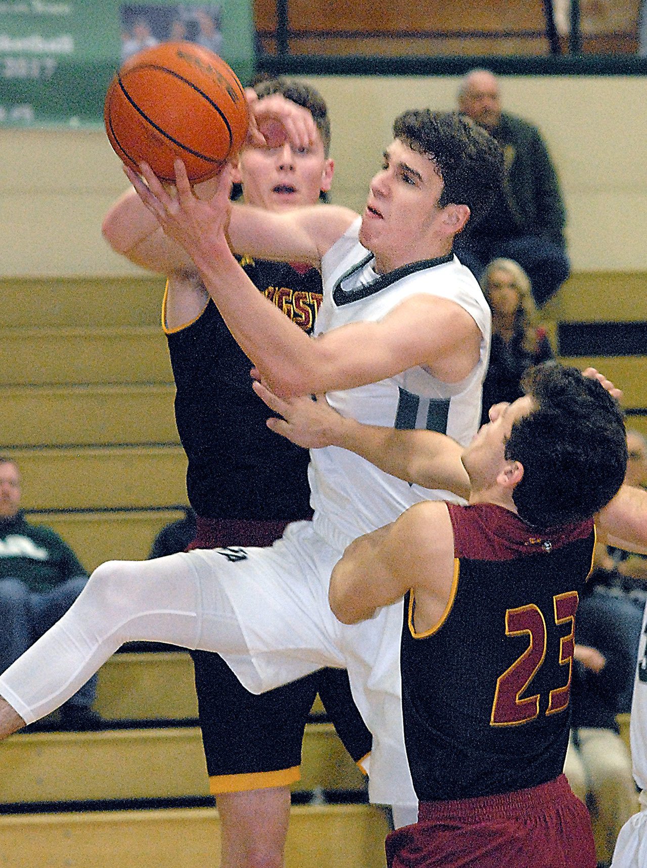 Keith Thorpe/Peninsula Daily News                                Port Angeles’ Luke Angevine, center, pulls down a rebound surrounded by Kingston’s Andrew Shaw, rear, and Isaac Anderson, front, in the second quarter of the Riders’ 68-46 loss to the Buccaneers.