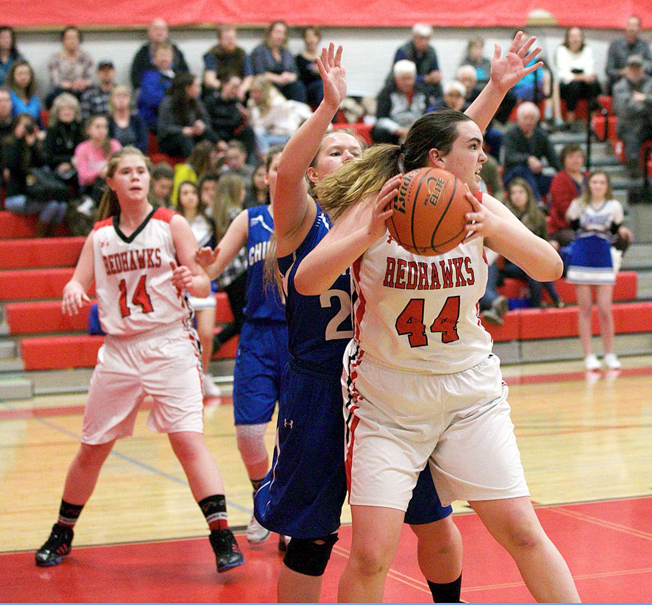 Steve Mullensky/for Peninsula Daily News Port Townsend’s Izzy Hammett looks for someone to pass the ball to while being guarded by Chimacum’s Shanya Nisbet during the Cowboys’ 42-28 win over the rival Redhawks.