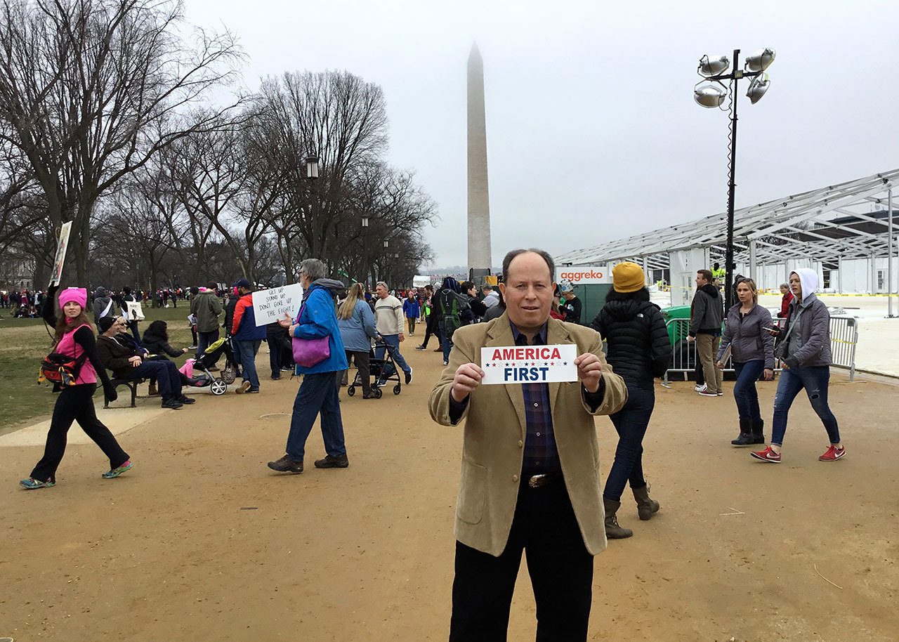 Joseph Lujan of Port Angeles stands with an “America First” sign during the Women’s March on Washington last week after he attended President Donald J. Trump’s inauguration Jan. 20.