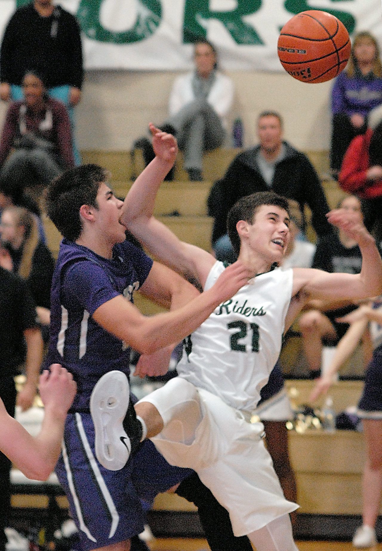 Keith Thorpe/Peninsula Daily News Sequim’s Payton Glasser, left, and Port Angeles’ Kyle Benedict tangle over a rebound during the second quarter on Friday night at Port Angeles High School.