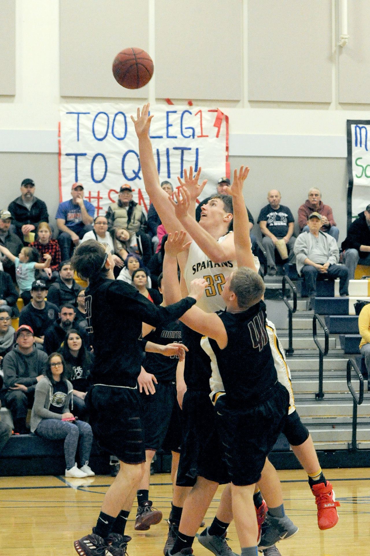 Lonnie Archibald/for Peninsula Daily News Forks’ Marky Adams scores over Montesano’s Nick Chapman (left) and Seth Dierkop (41) Tuesday night in Forks during this critical league matchup. The Spartans held on and won 67-62 over the Bulldogs.