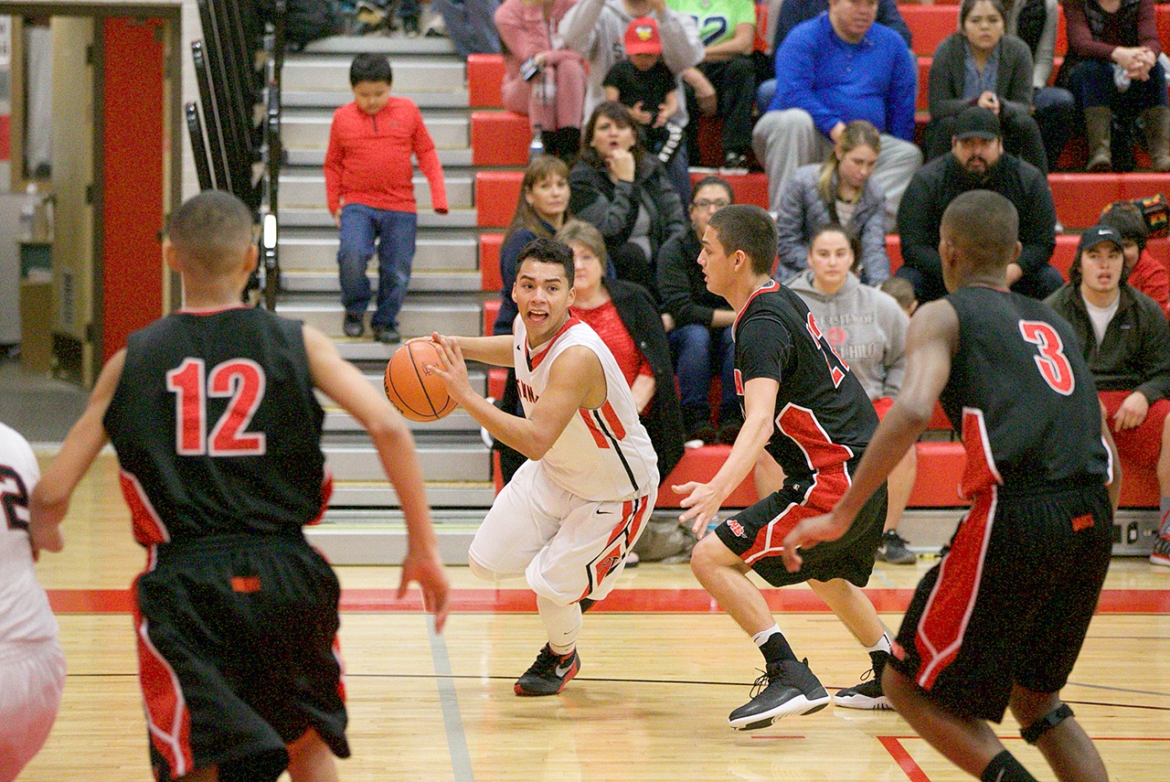 Steve Mullensky/for Peninsula Daily News Nea Bay, in black, and Port Townsend, inwhite jerseys, represent the opposite ends of the spectrum when it comes to the effect of the WIAA’s new RPI system. Pictured are Port Townsend’s Jacob Boucher and Neah Bay’s Sean Bitegeko (12), Kendrick Doherty (22), and Anthony Bitegeko (3) during the Crush in the Slush at Port Townsend High School in December.