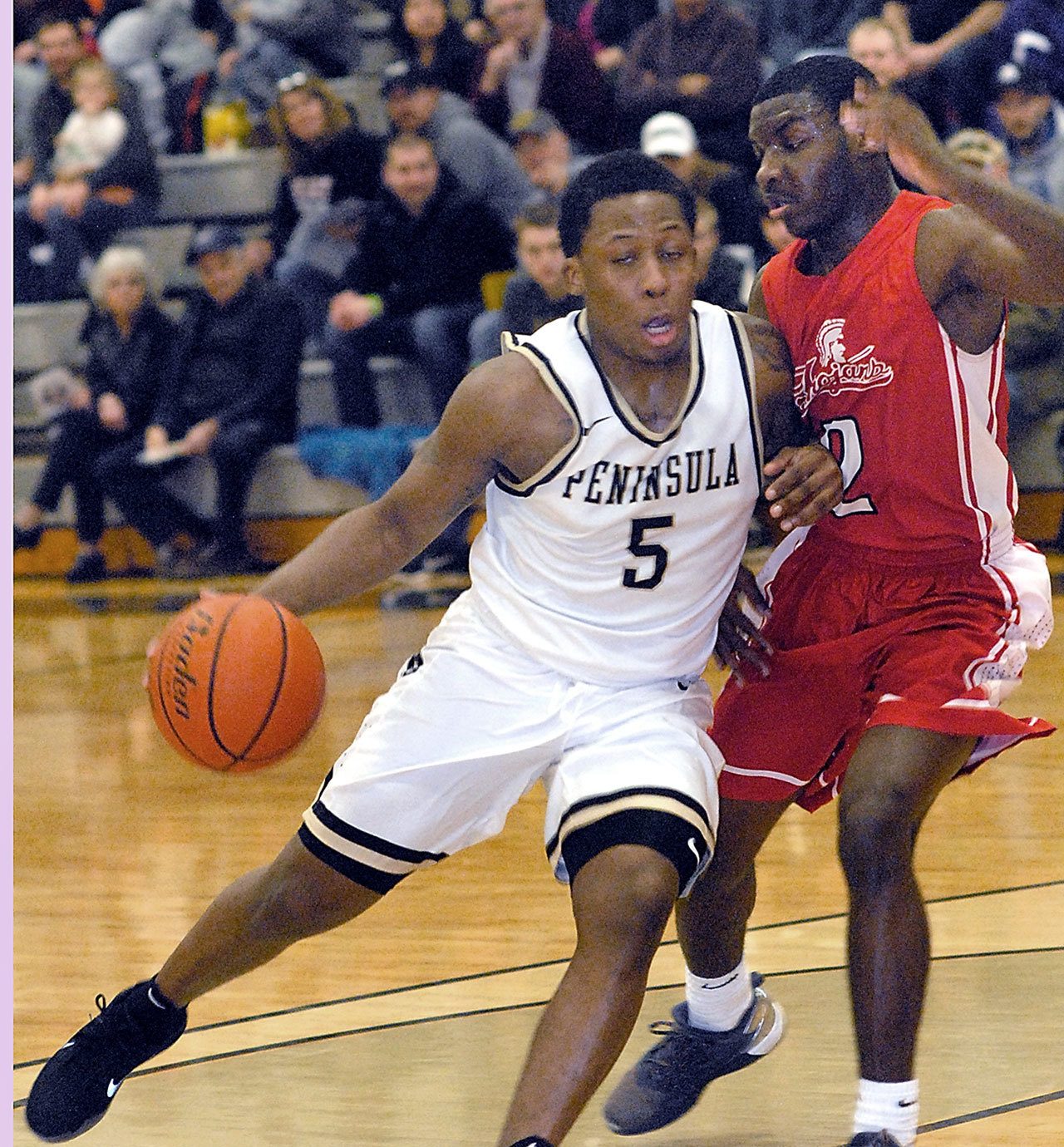 Keith Thorpe/Peninsula Daily News Peninsula’s Darrion Daniels, left, sweeps around Everett’s Gio Jackson in first half play on Saturday night in Port Angeles.