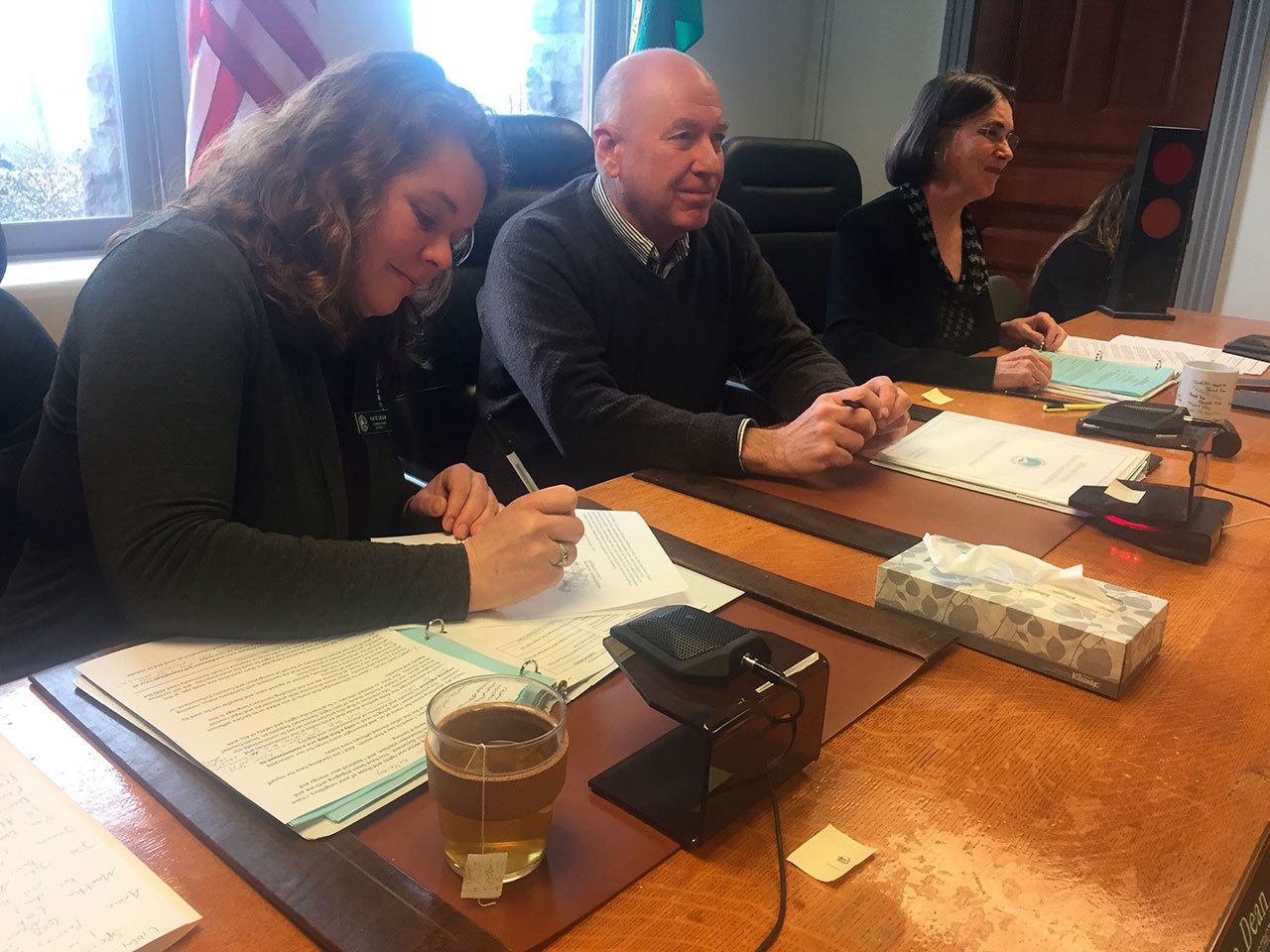 Jefferson County commissioners Kate Dean, David Sullivan and Kathleen Kler sign a human rights proclamation for Jefferson County at their meeting Monday morning. (Cydney McFarland/Peninsula Daily News)