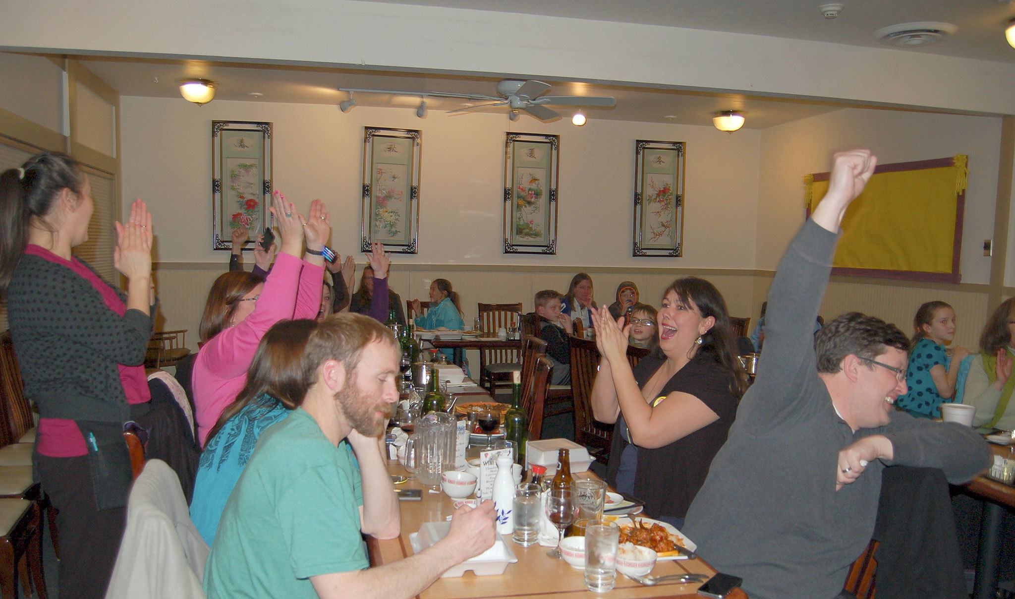 From left, Jim Bell, Nathan Adkisson, Jodi Minker and others celebrate as Superintendent Gary Neal announces the approval of both levies Tuesday night. (Erin Hawkins/Olympic Peninsula News Group)