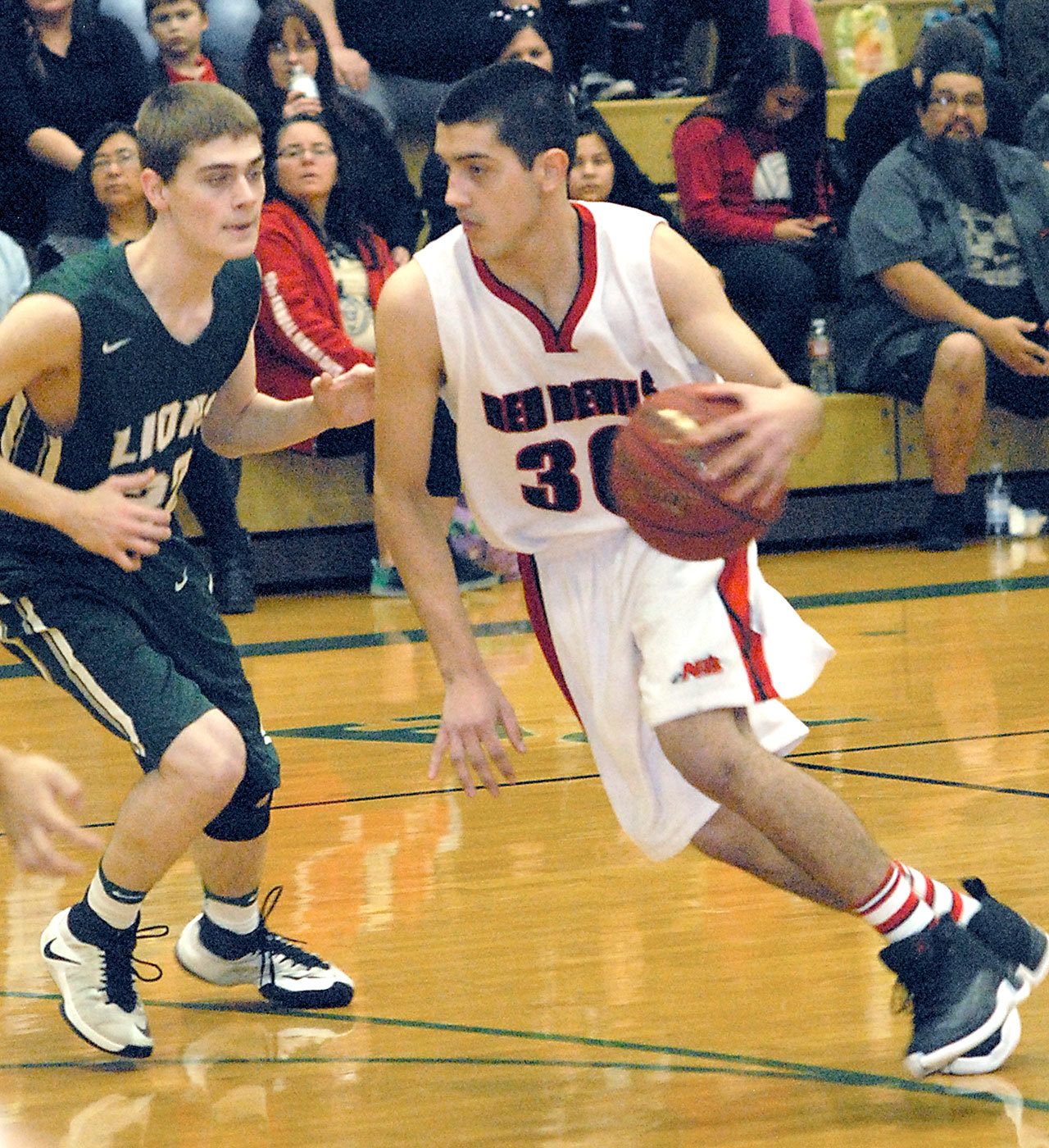 Keith Thorpe/Peninsula Daily News Neah Bay’s Cameron Moore, right, dribbles past Cedar Park Christian’s Jacob Schley during their playoff game on Feb. 16 at Port Angeles High School.