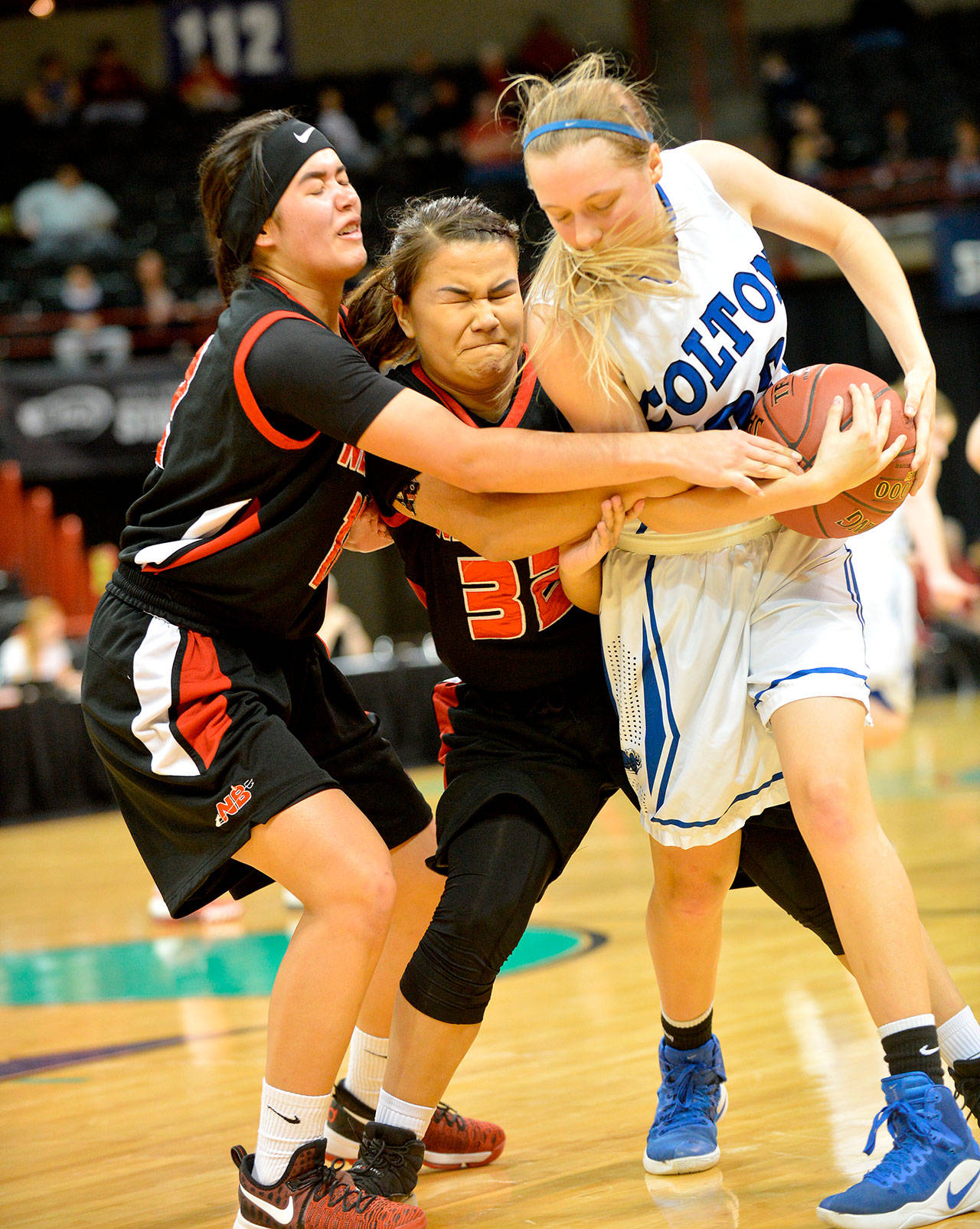 Al Camp/Omak-Okanogan County Chronicle                                Neah Bay’s Vonte Aguirre and Starlena Halttunen fight for a ball with a Colton player during Neah Bay’s second-round tournament loss Thursday. Neah Bay remains alive in the tournament and will play Tacoma Baptist Friday.