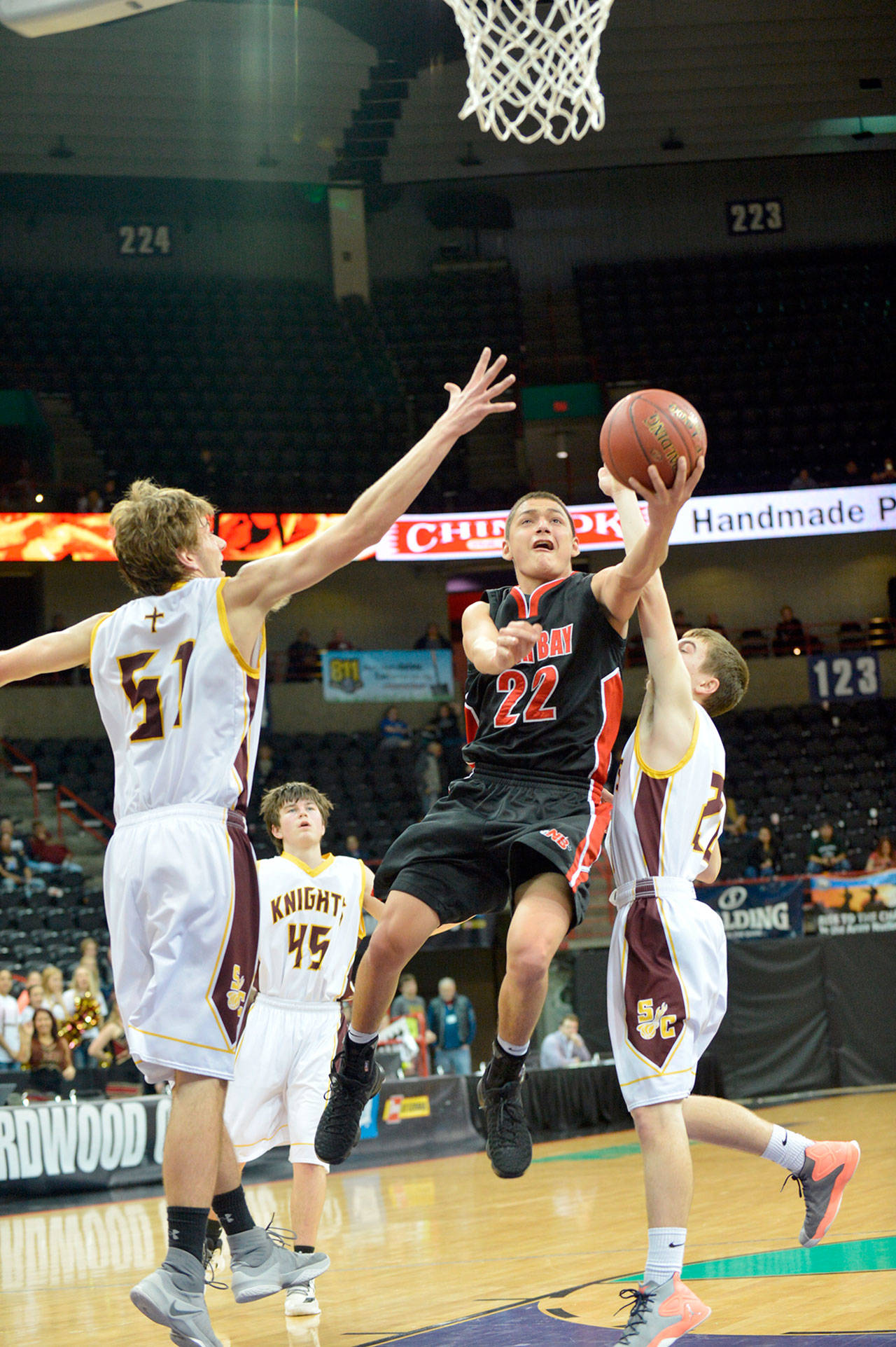 Al Camp/Omak Chronicle Neah Bay’s Kenrick Doherty Jr. lays up a shot while defended by Sunnyside Christian’s Luke Wagenaar during the Red Devils’ 58-48 loss to the Knights at Spokane Arena.