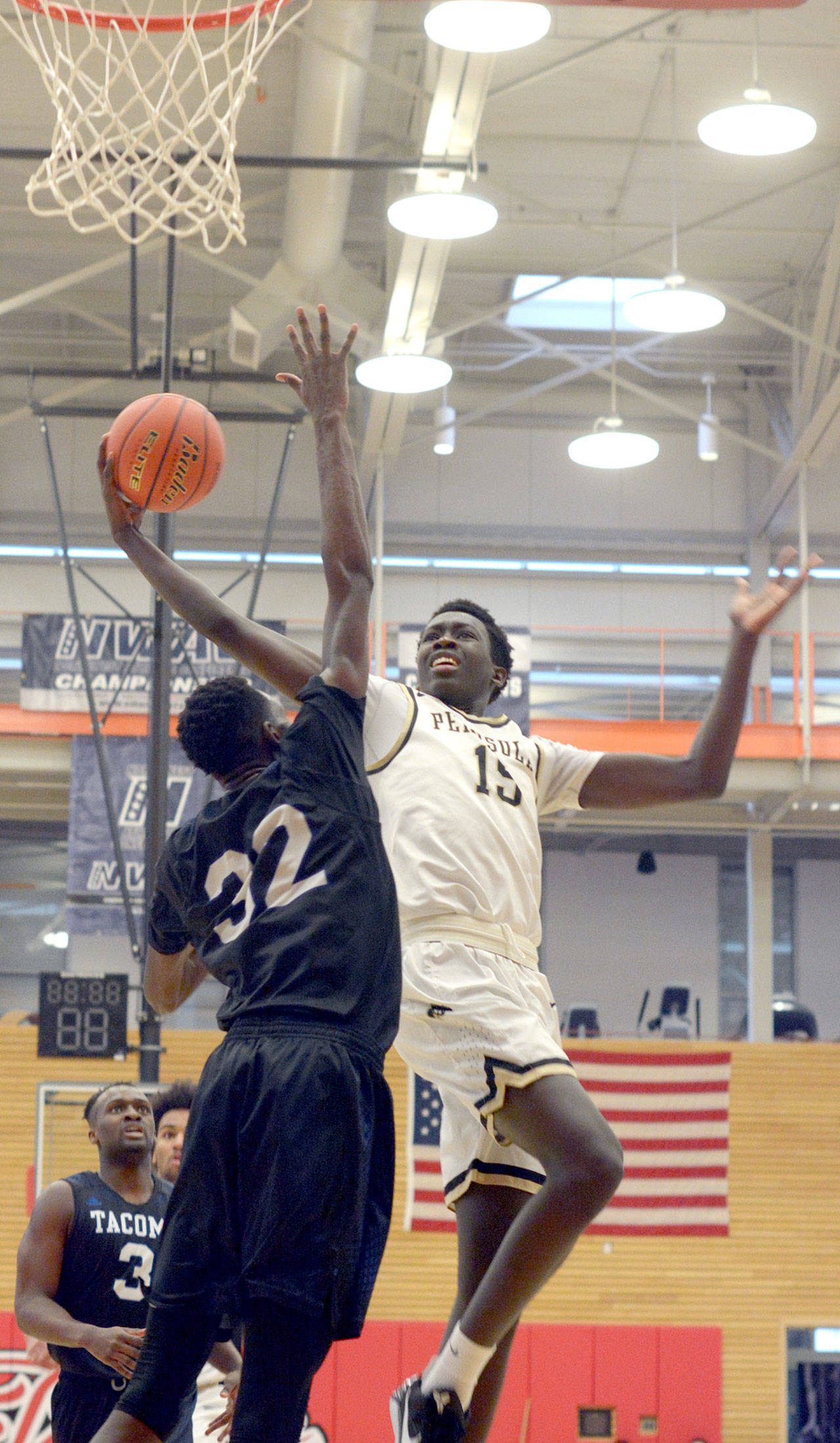 Rick Ross/Peninsula College                                Peninsula’s Omar Lo, right, attacks the rim against the defense of Tacoma’s Ravion Bell during the Pirates’ 75-64 loss to the Titans on Friday at Everett Community College.