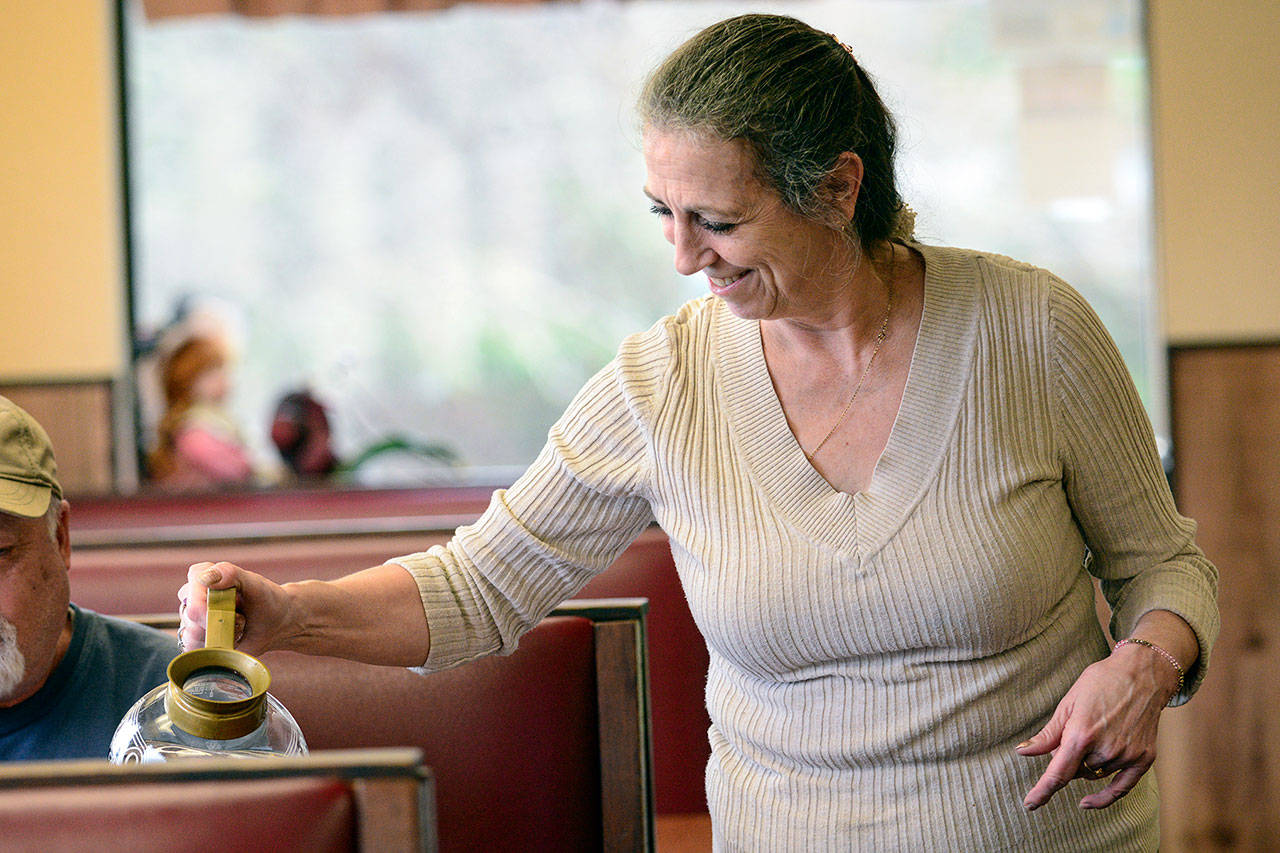 Blackberry Cafe owner Roxanne Olsen pours coffee for customers. Olsen is frustrated by break-ins of her restaurant, with the most recent being last week. (Jesse Major/Peninsula Daily News)