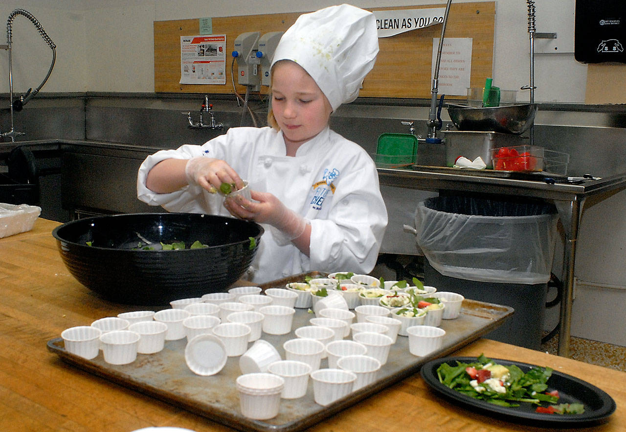 Nine-year-old Zoe Leffers, a fourth-grade student at Hamilton School in Port Angeles, creates a healthy salad Friday in the Port Angeles School District kitchen as part of the 2017 Sodexo Future Chefs Challenge. The event, part of a national initiative to promote healthy eating, brought together student teams from five Port Angeles elementary schools in a competition to cook up culinary creations with the theme of “Healthy Comfort Foods.” (Keith Thorpe/Peninsula Daily News)