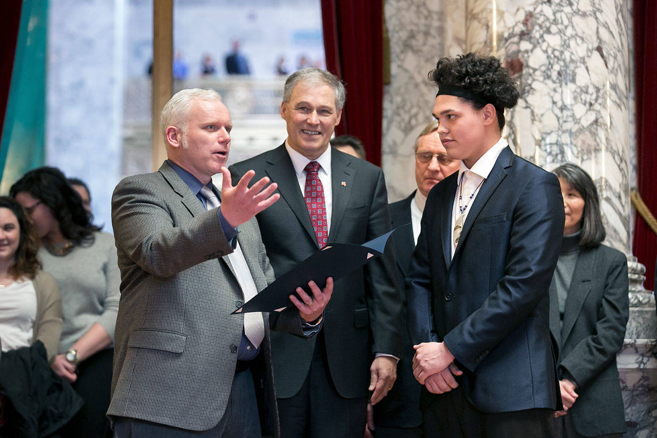 Neah Bay football player Nate Tyler, right, listens as Sen. Kevin Van De Wege discusses his school’s athletic and academic accomplishments as Gov. Jay Inslee looks on during a ceremony at the State Capitol in Olympia on Wednesday. Tyler’s father, Nate Tyler Sr. is the Makah tribal chair.