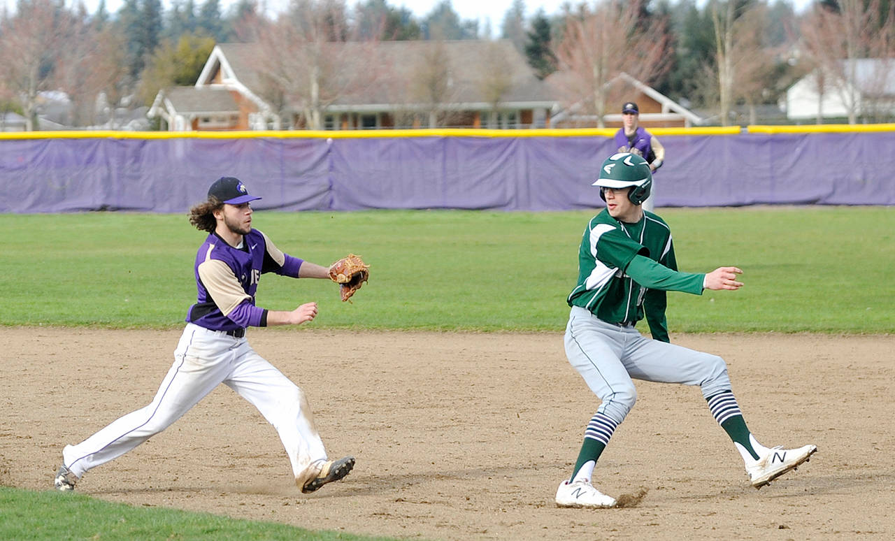 Michael Dashiell/Olympic Peninsula News Group Port Angeles’ Luke Angevine, right, attempts to avoid a rundown by Sequim’s Gavin Velarde. Angevine was tagged out, but his Roughriders rallied for a 10-7 win.