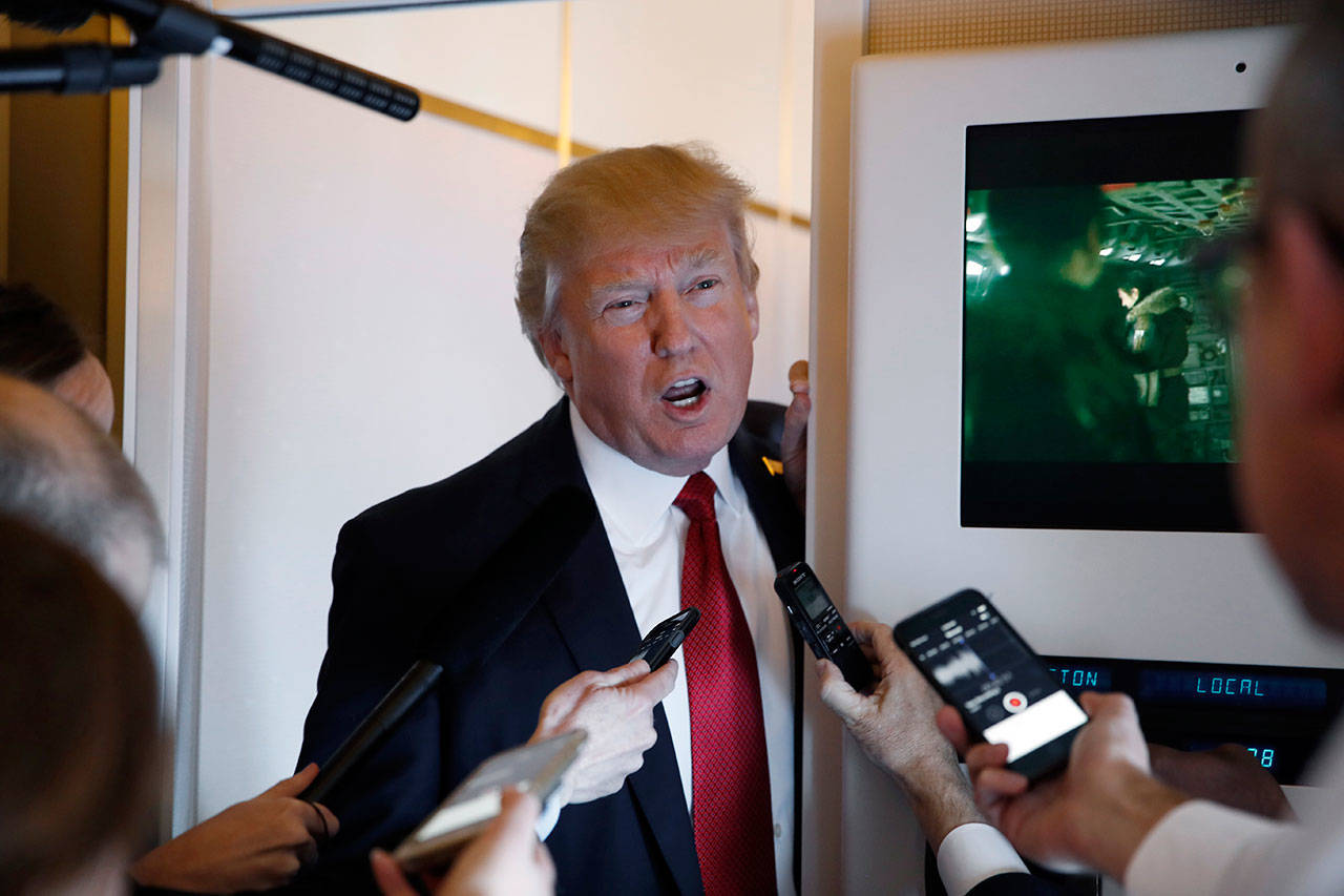 President Donald Trump speaks with reporters on Air Force One while in flight from Andrews Air Force Base, Md., to Palm Beach International Airport, Fla., on Thursday. (Alex Brandon/The Associated Press)