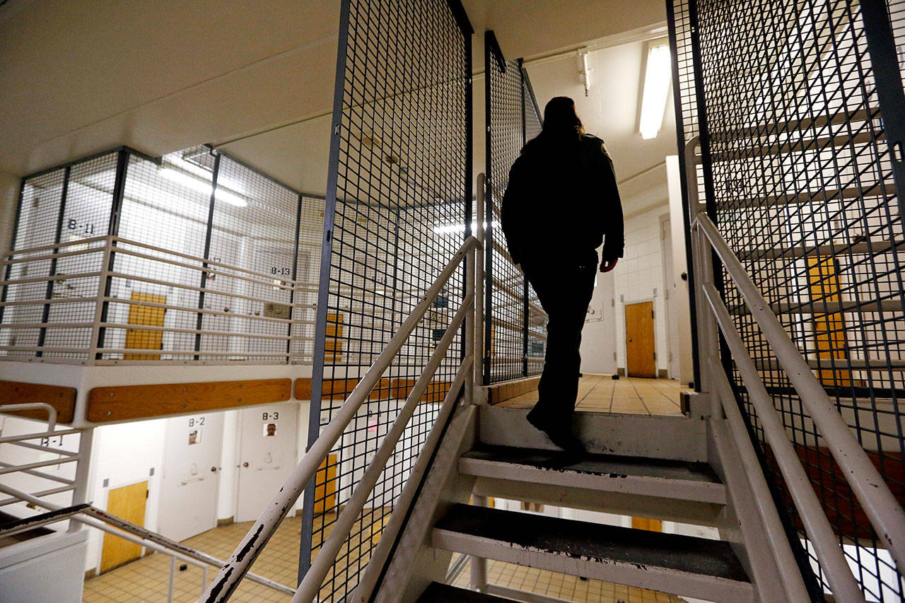 A corrections deputy walks to the upper level of a unit of the Pierce County Jail in Tacoma on Oct. 15, 2014. (Elaine Thompson/The Asociated Press)