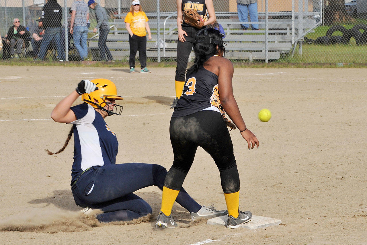 Lonnie Archibald/for Peninsula Daily News                                Spartan baserunner Rian Peters slides safely into third base ahead of the throw to North beach third baseman Adelina Desamours in the second game of a doubleheader Tuesday. Forks took the first game 16 to 1 and the second game 19 to 0.