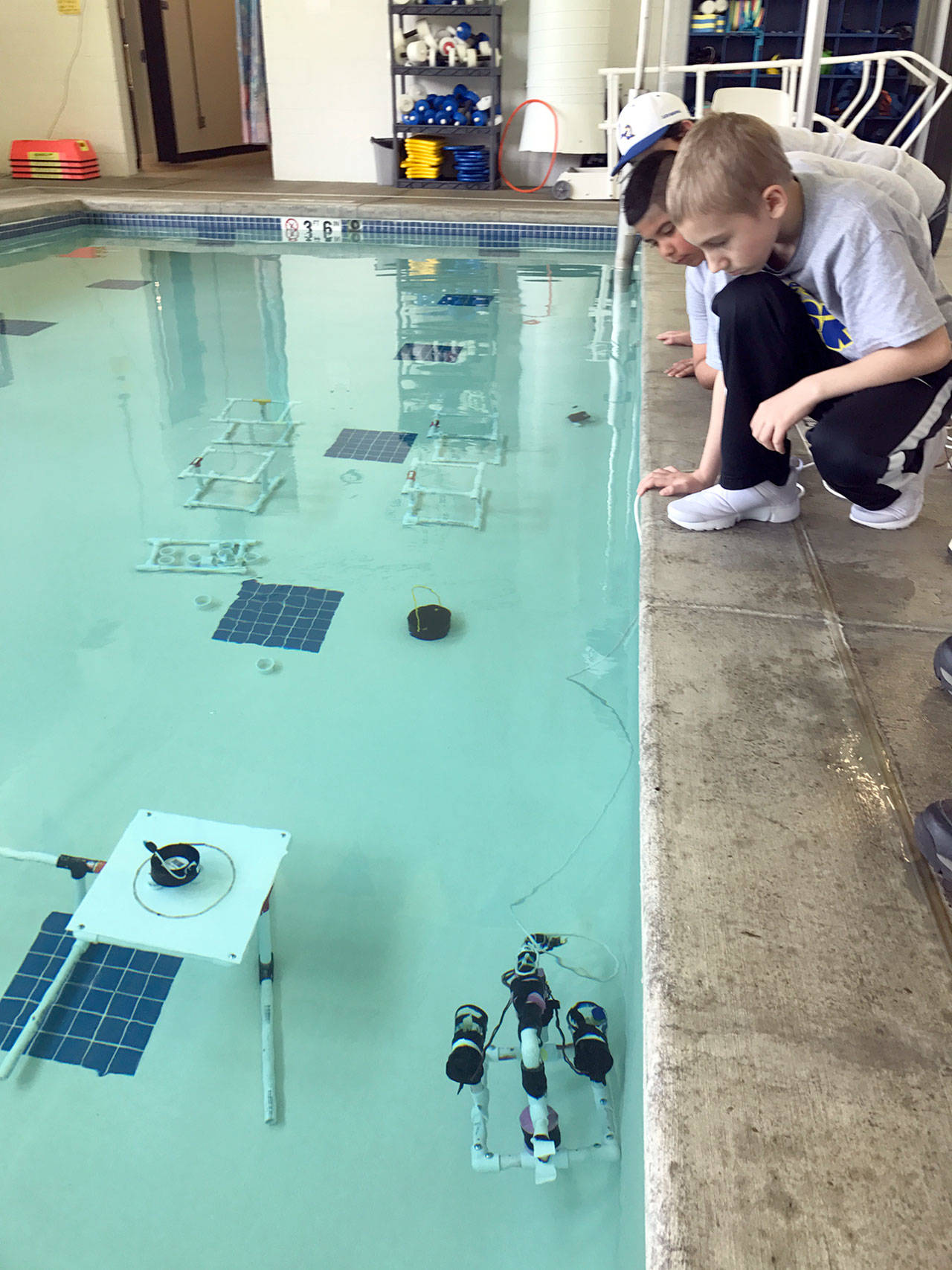 Students peer into the water at the Forks Athletic and Aquatic Center’s pool at a remote-operated vehicle during the MATE ROV competition. (Olympic Coast National Marine Sanctuary)