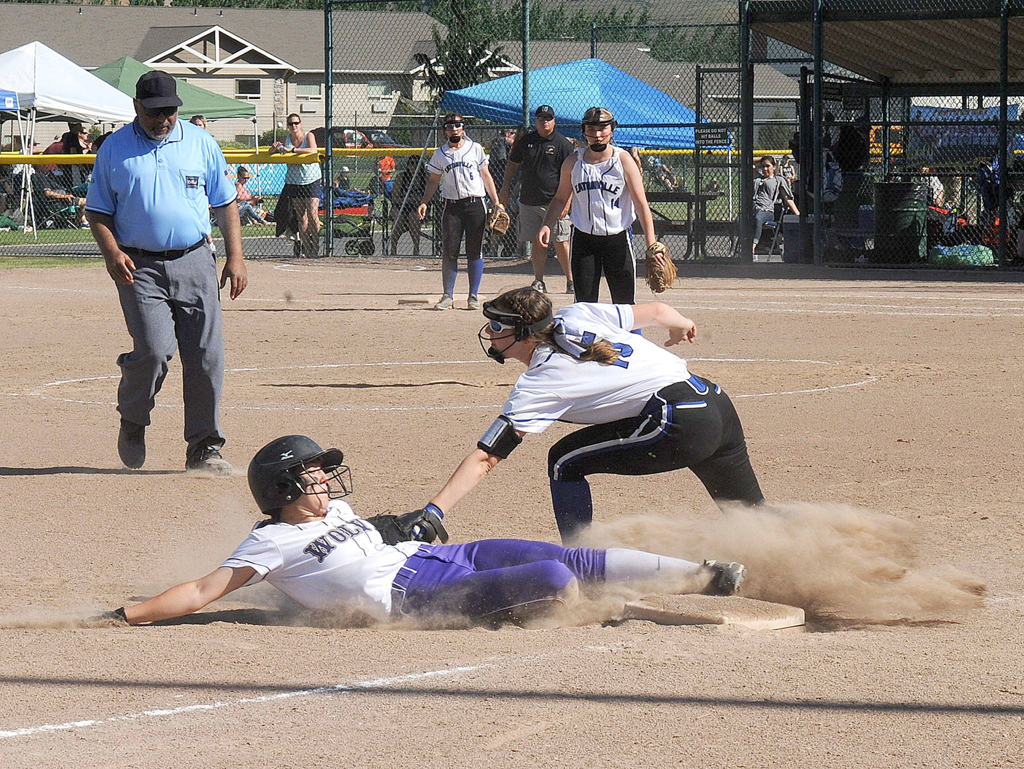 Lonnie Archibald/for Peninsula Daily News Sequim’s Jordan Bentz slides into third and was called out on this close play in the Wolves’ 2A state tournament game against Eatonville. Covering for Eatonville is Stella Eslinger.