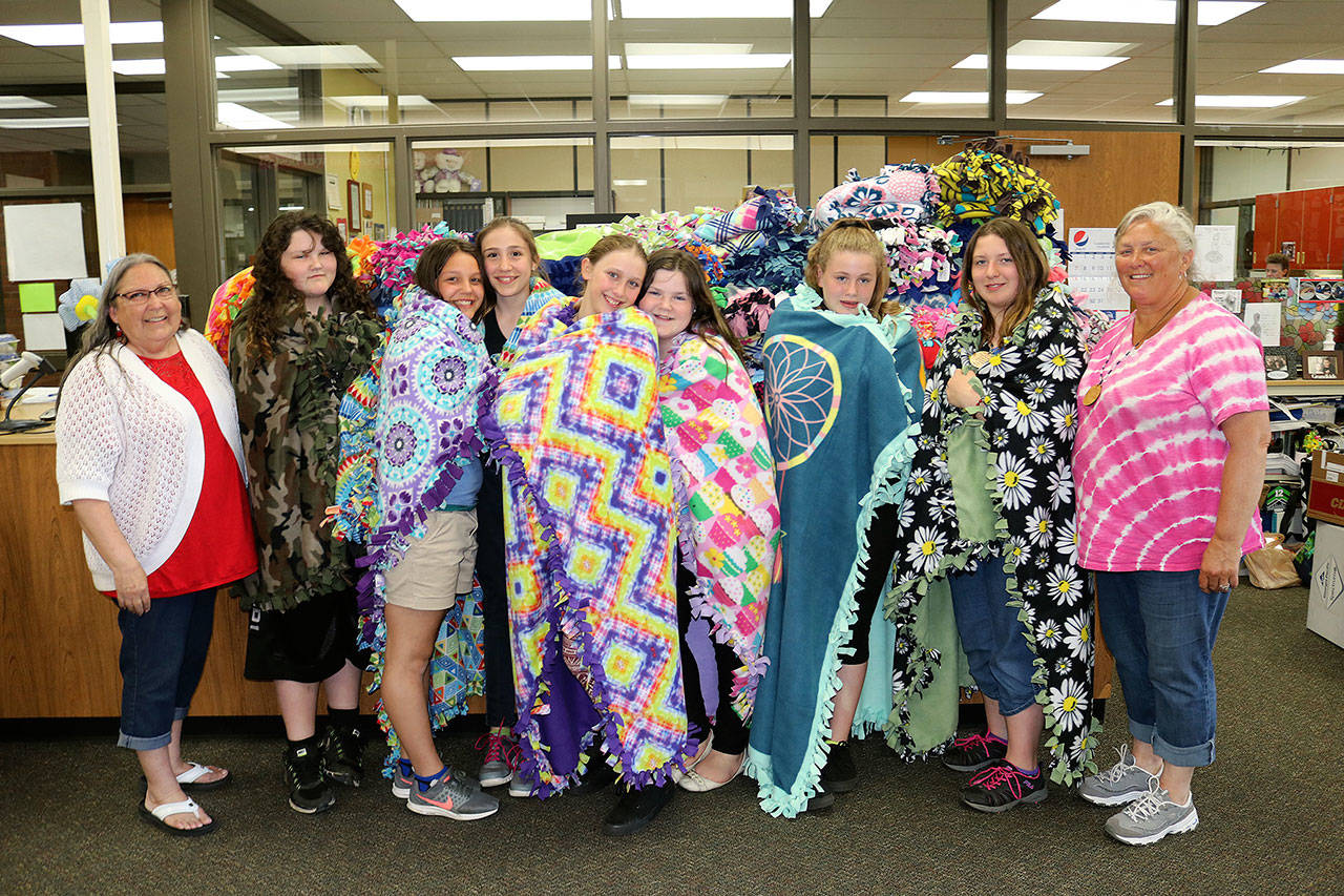 Stevens Middle School students display blankets made this year for Seattle Children’s Hospital patients. Pictured from left are advisor Evelyn Ellsworth, Maddy Wray, Amiya Bowen, Kiersten Jensen, Mya Lindstrom, Olivia Wray, Keaona Walker, Emma Runnels and volunteer Carol Hughes. (Port Angeles School District)