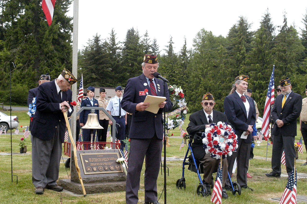 John Kent, Veterans of Foreign Wars Post 1024 commander, at microphone, speaks at a Memorial Day ceremony at Mount Angeles Memorial Park cemetery Monday. Kent is flanked by Korean War veteran Richard Smelling, left; World War II veteran Tom McKeown, right, seated; and other members of VFW Post 1024. (Rob Ollikainen/Peninsula Daily News)