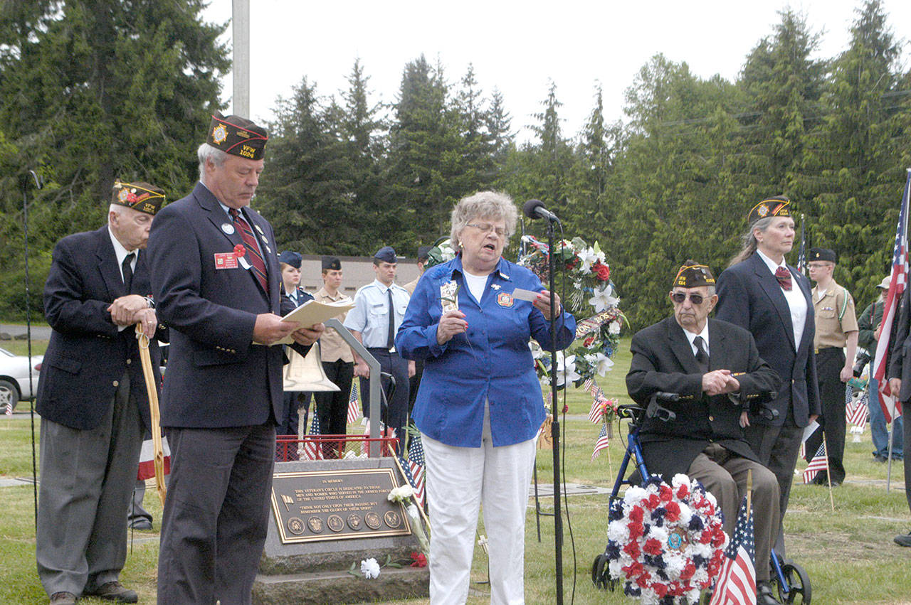 Patricia Foster of Veterans of Foreign Wars Auxiliary 1024 speaks at a Memorial Day ceremony at Mount Angeles Memorial Park cemetery on Monday. She is flanked by Richard Smelling of VFW Post 1024, far left, post Commander John Kent, post Trustee Tom McKeown and post Chaplain Sonja Schimmele. (Rob Ollikainen/Peninsula Daily News )