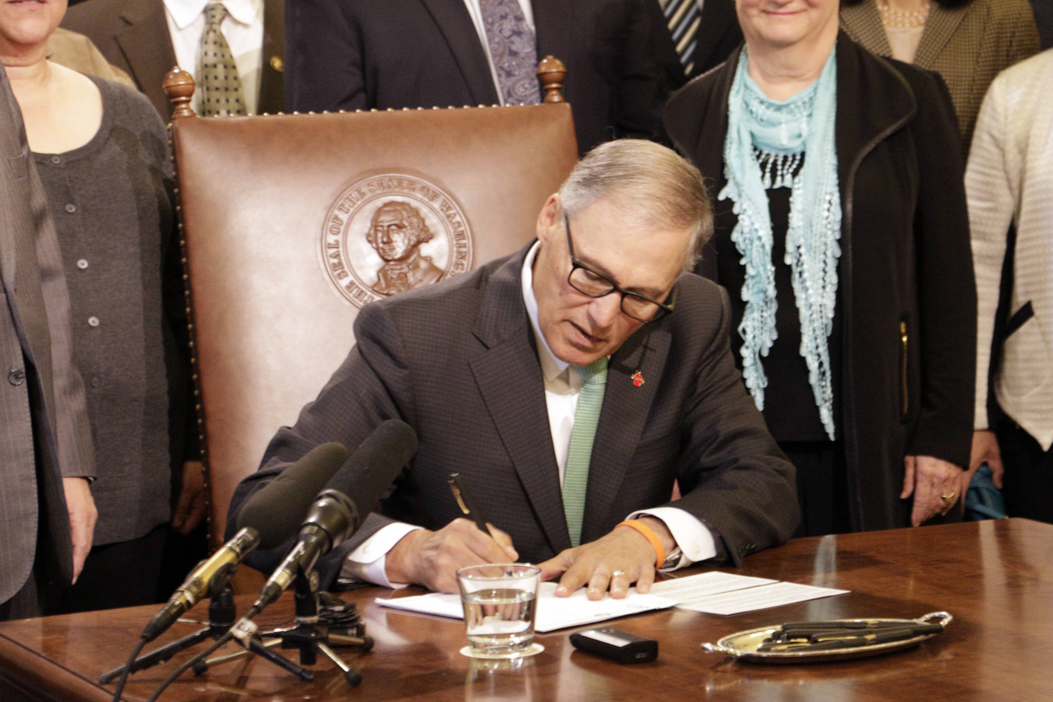 Gov. Jay Inslee signs a bill Tuesday in Olympia that seeks to bring Washington state into compliance with the federal REAL ID Act. (Rachel La Corte/The Associated Press)