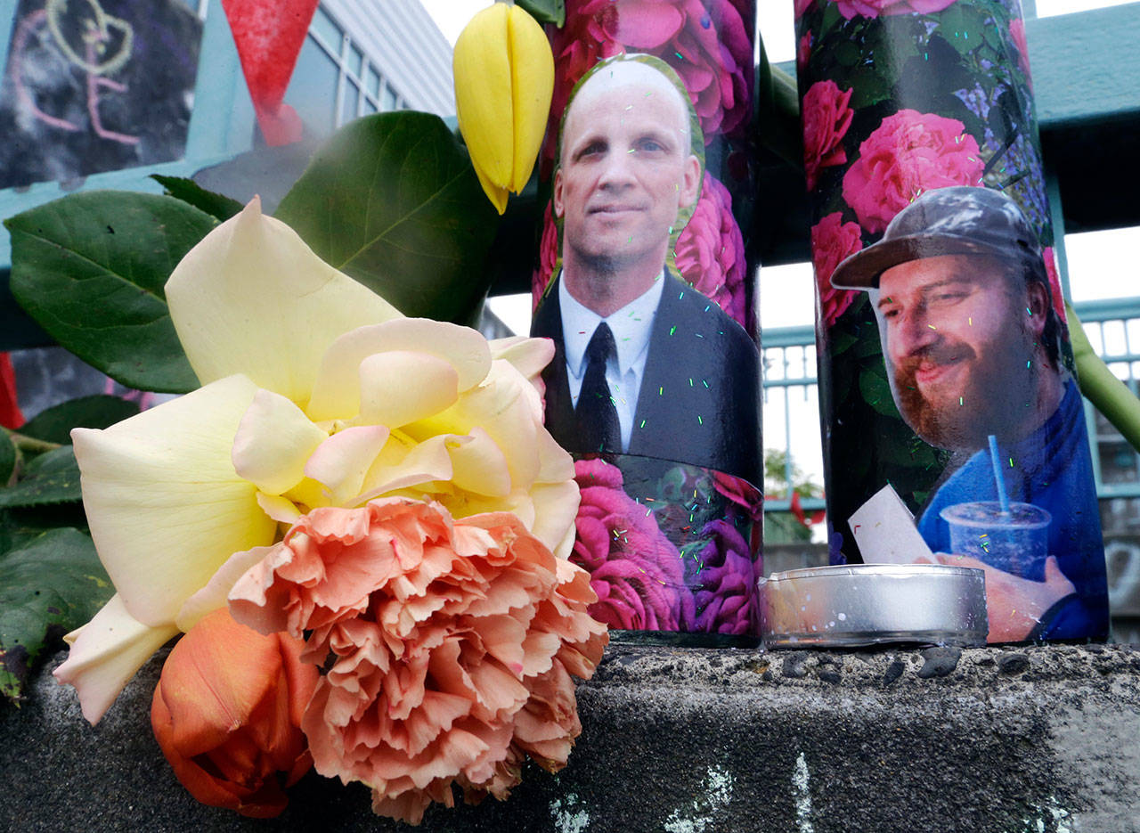 Candles with photos of Taliesin Namkai-Meche, right, and Ricky Best on them sit at a memorial for the two men in Portland, Ore., on May 31. (Don Ryan/The Associated Press)