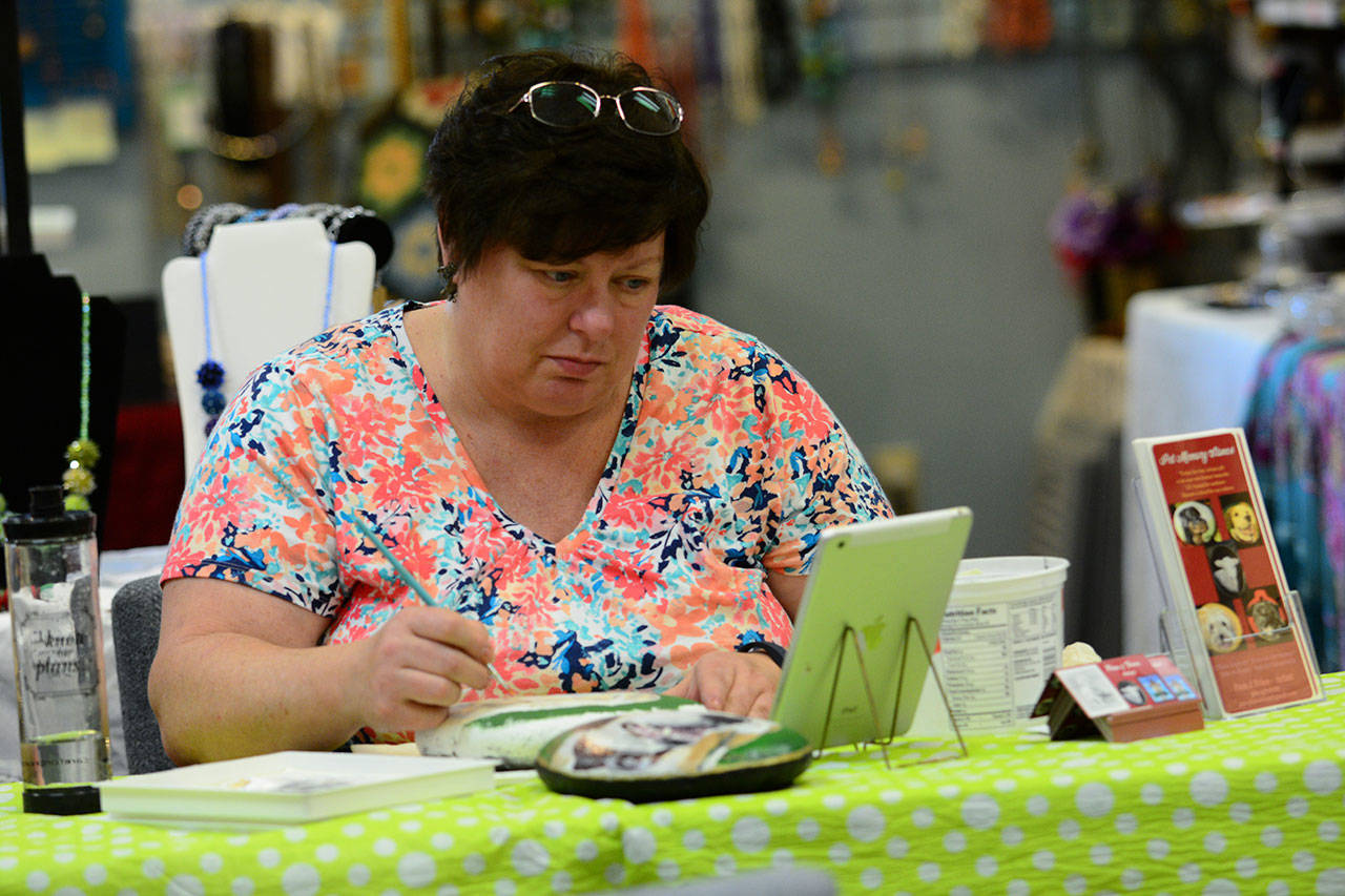 Pam Fries paints at the Landing Artist Studio in Port Angeles last week. (Jesse Major/Peninsula Daily News)