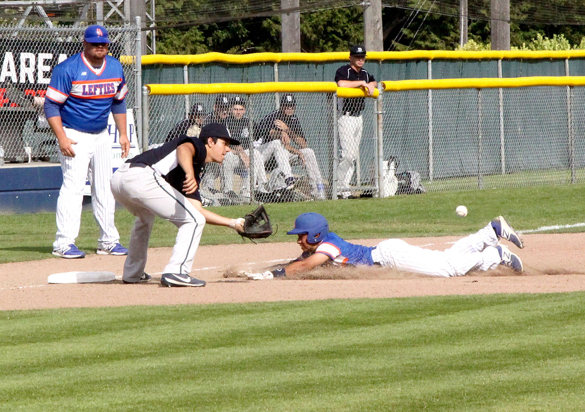 Dave Logan/for Peninsula Daily News Lefties baserunner Austyn Tengan slide safely into third base as the Bellingham Bells third baseman Ernie Yake waits for the ball to arrive